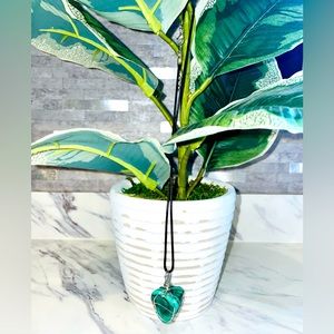 Malachite amazing stone sits in the middle of metal silver work on black chain